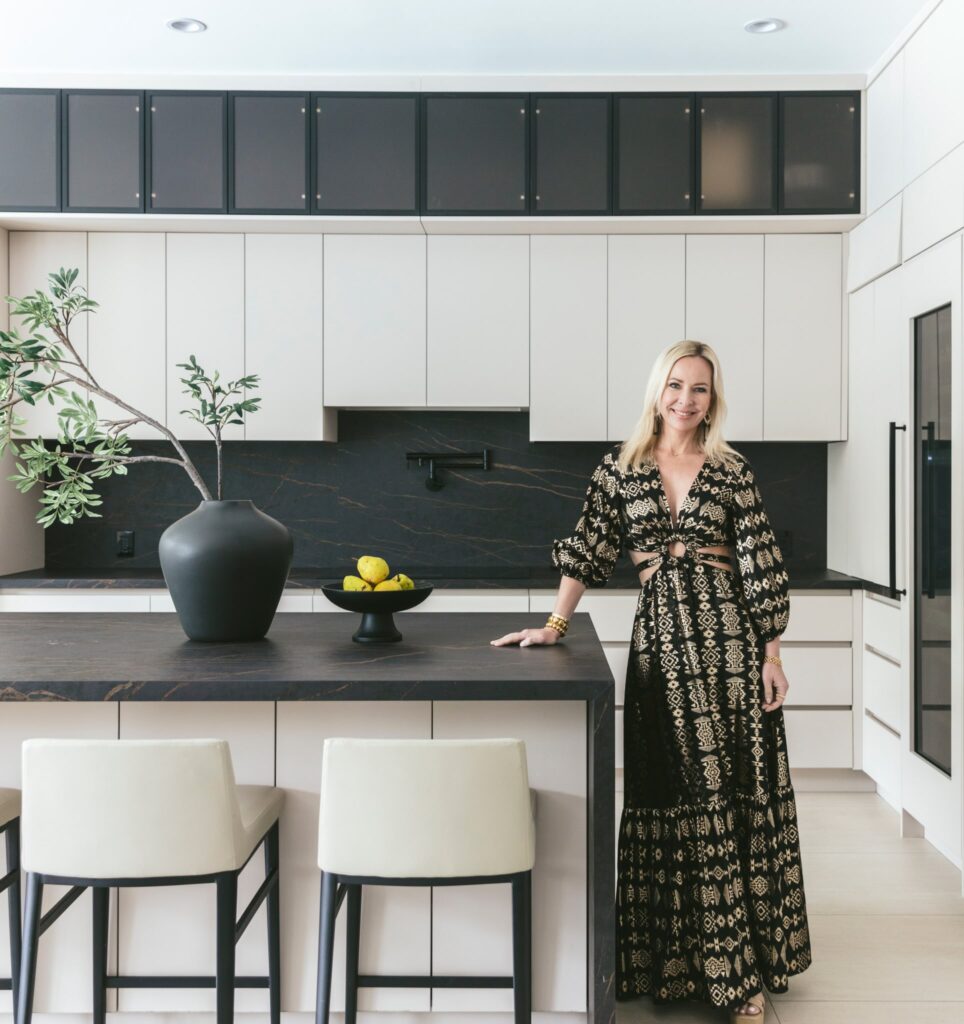 Designer standing in contemporary kitchen.