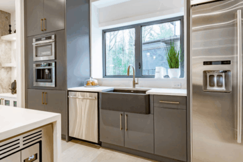 Modern grey kitchen with integrated stainless steel appliances and wall ovens