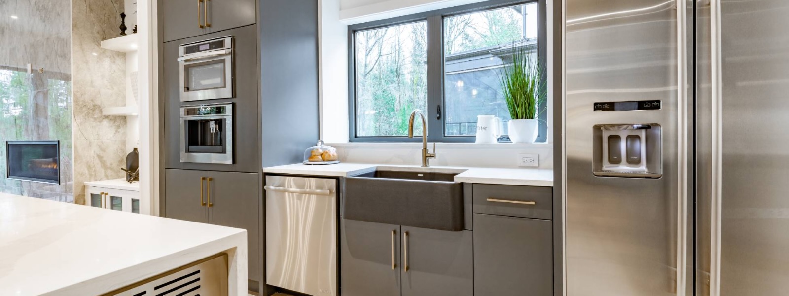 Modern grey kitchen with integrated stainless steel appliances and wall ovens