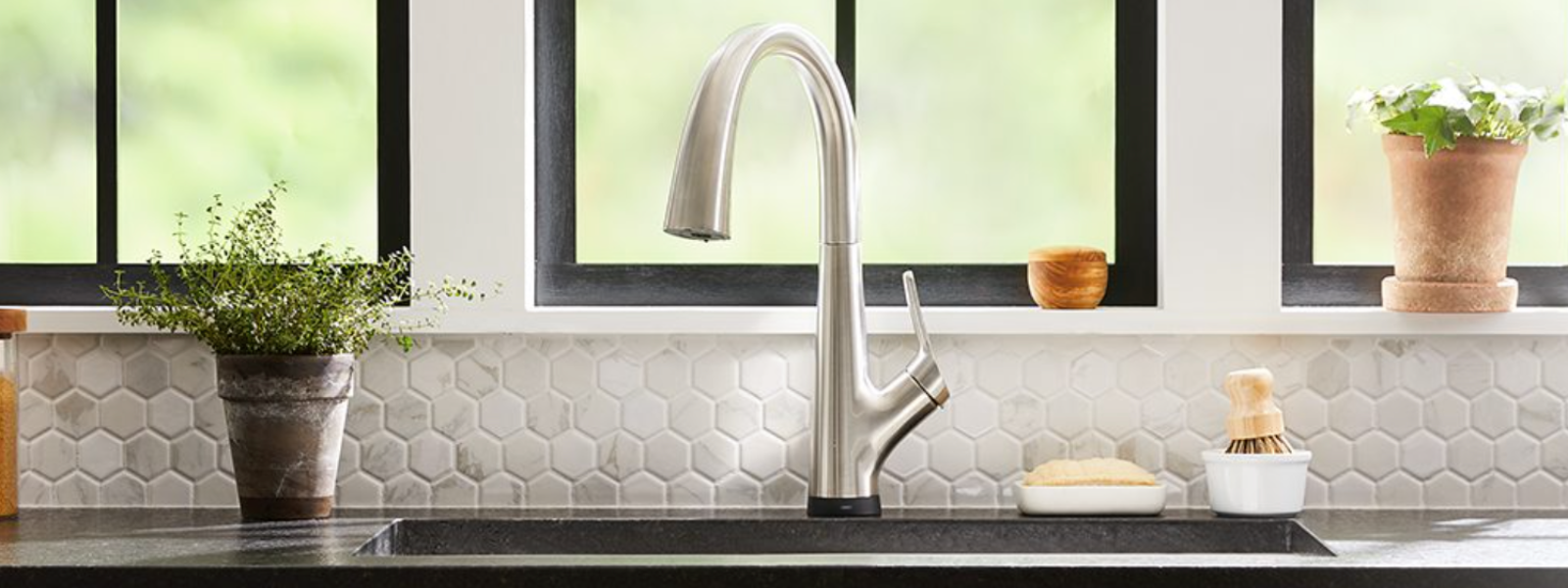 Brushed nickel kitchen faucet, undermount sink, and marble tile backsplash