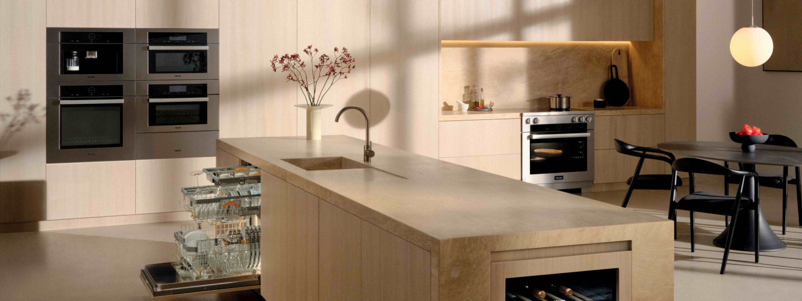 Seamless modern kitchen with integrated Miele wall ovens, island dishwashers, built-in wine fridge, and warm wood finishes